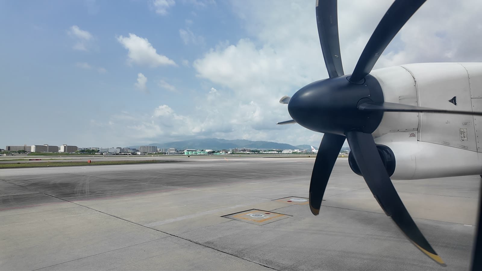 DHC8-Q400の窓から見えるプロペラと伊丹空港の滑走路